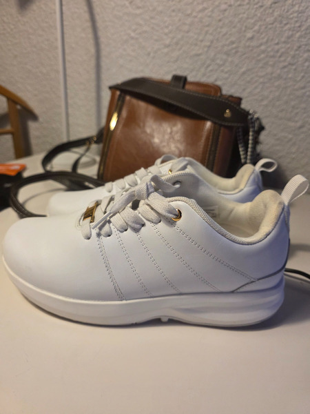 Hvítir strigaskór með gylltum smáatriðum